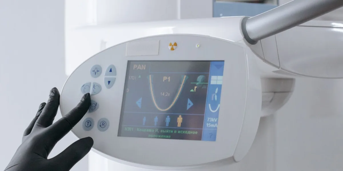 Mano con guante configurando el panel de control de un equipo médico